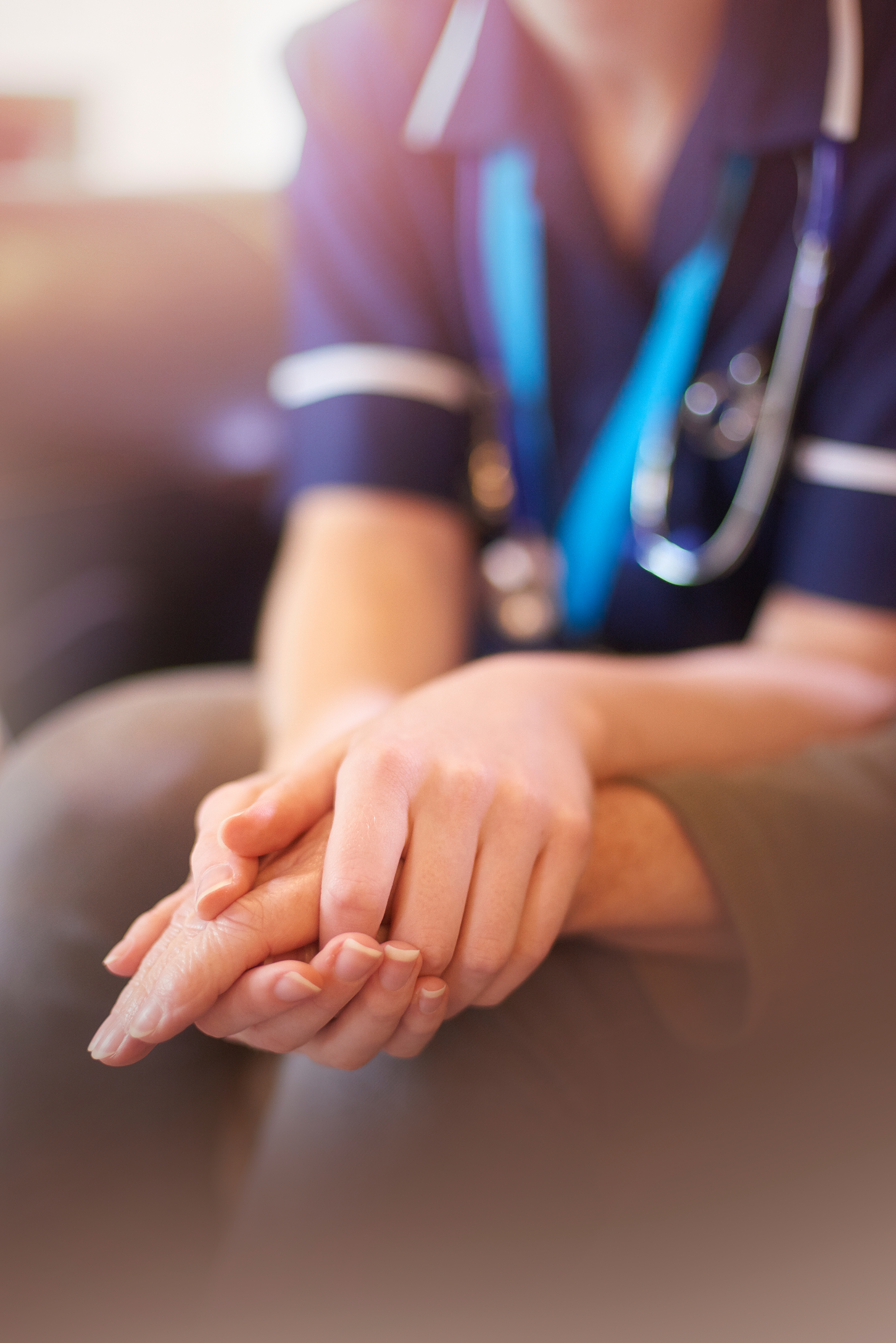 Nurse holding patients hands