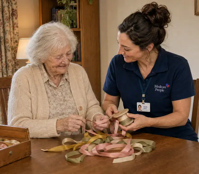 Live-in carer sorting a box of ribbons with an older woman at the dining table Live-in carer sorting a box of ribbons with an older woman at the dining table